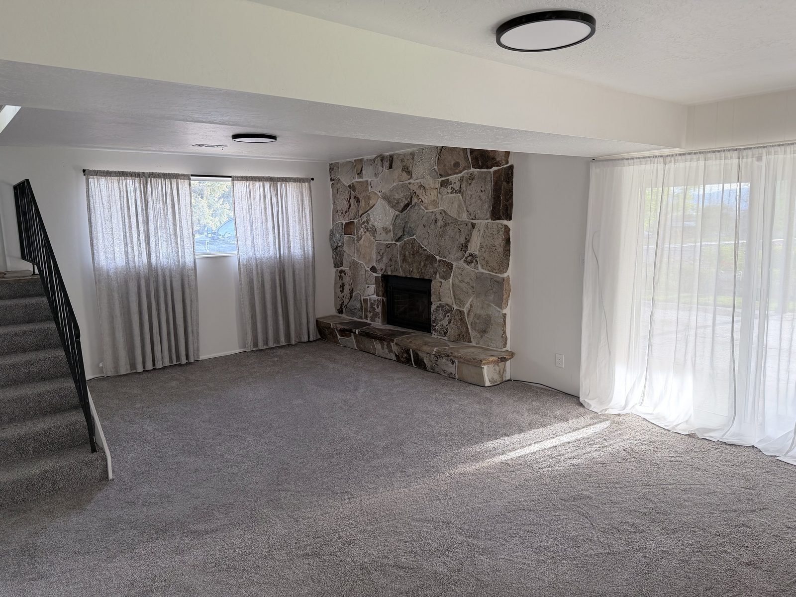 Daylight-basement family room with stone fireplace